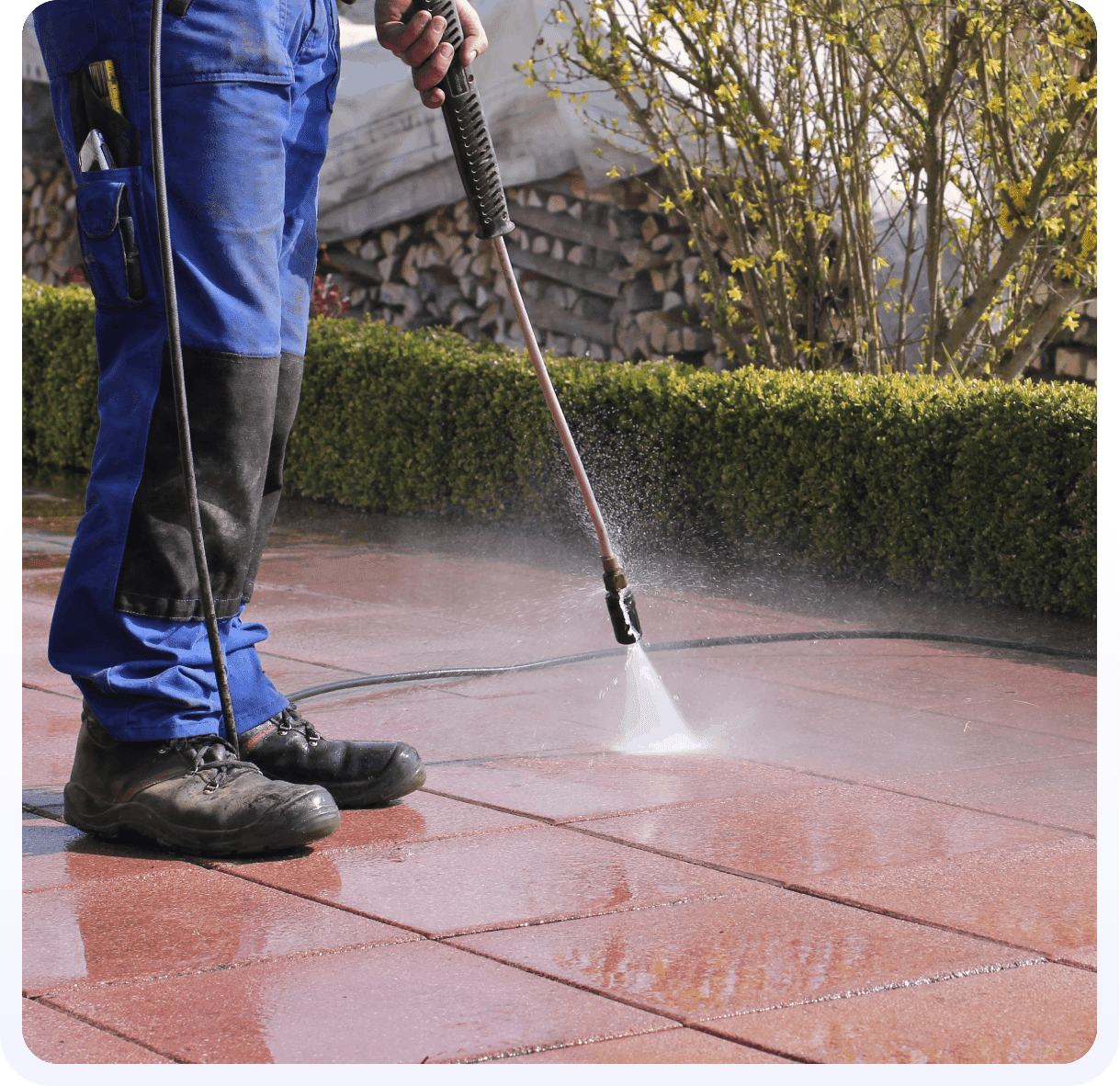 A person using a power washer on the ground.