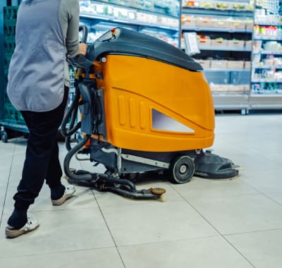 A person is standing next to an orange machine.