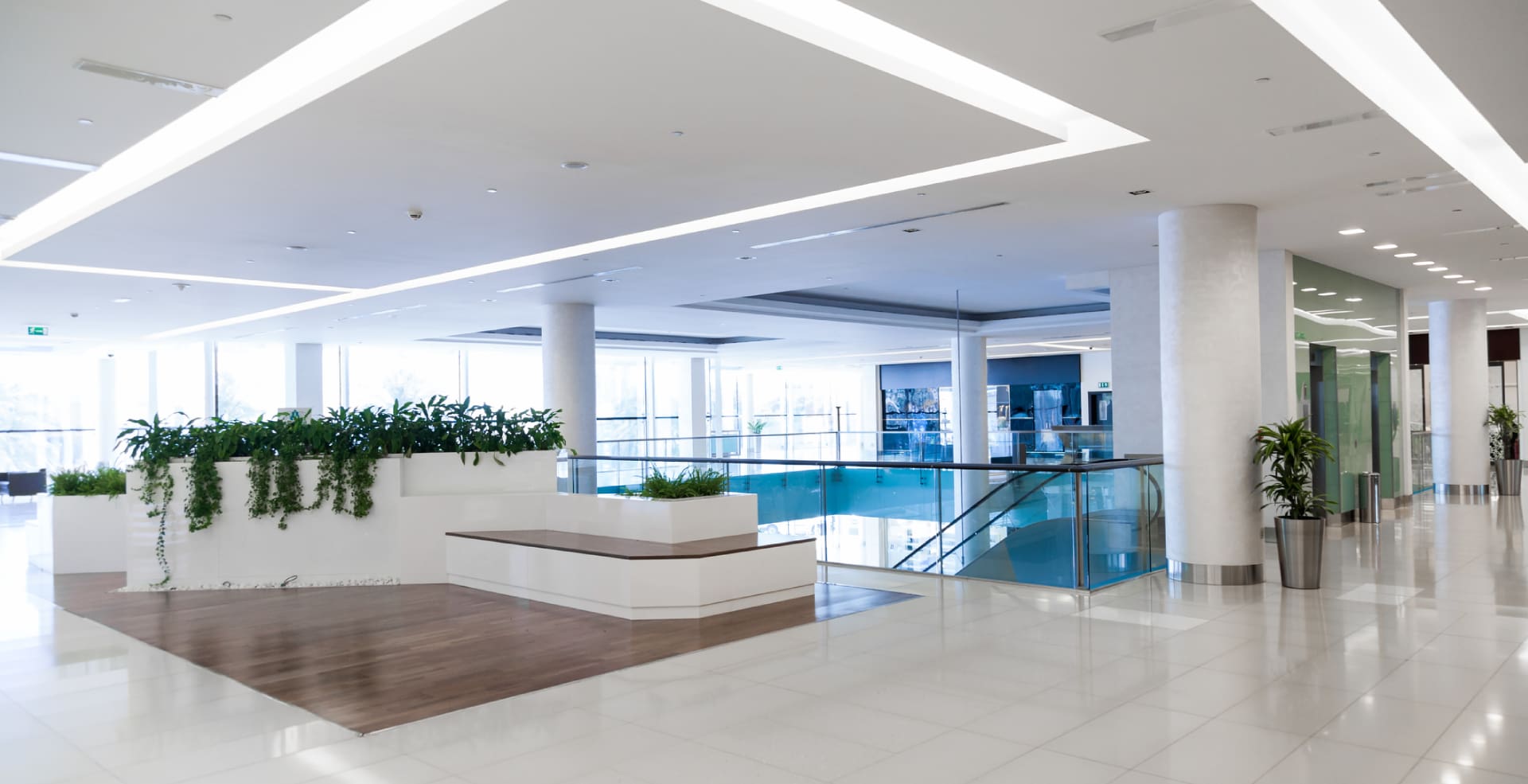 A lobby with a bench and stairs in the background.