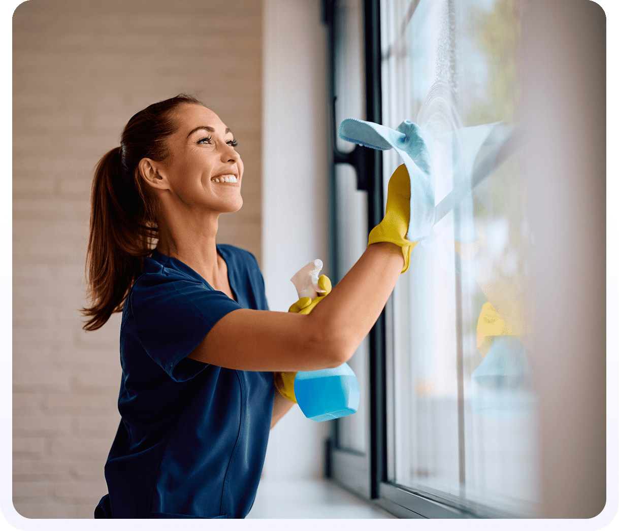 A woman cleaning windows with a cloth and rubber glove.